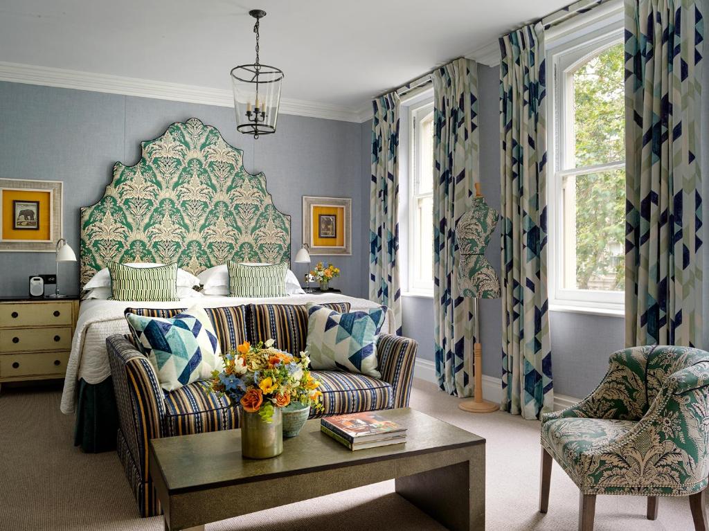 a bedroom with a bed and a chair and a table at Knightsbridge Hotel, Firmdale Hotels in London