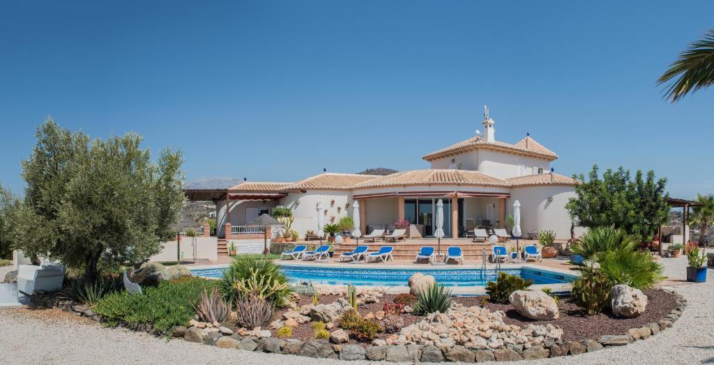 a villa with a swimming pool and a resort at B&B El Pajarero in Arenas
