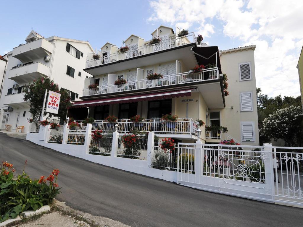 a white building with flowers on the balconies at Hotel Haus Am Meer Cavtat in Cavtat