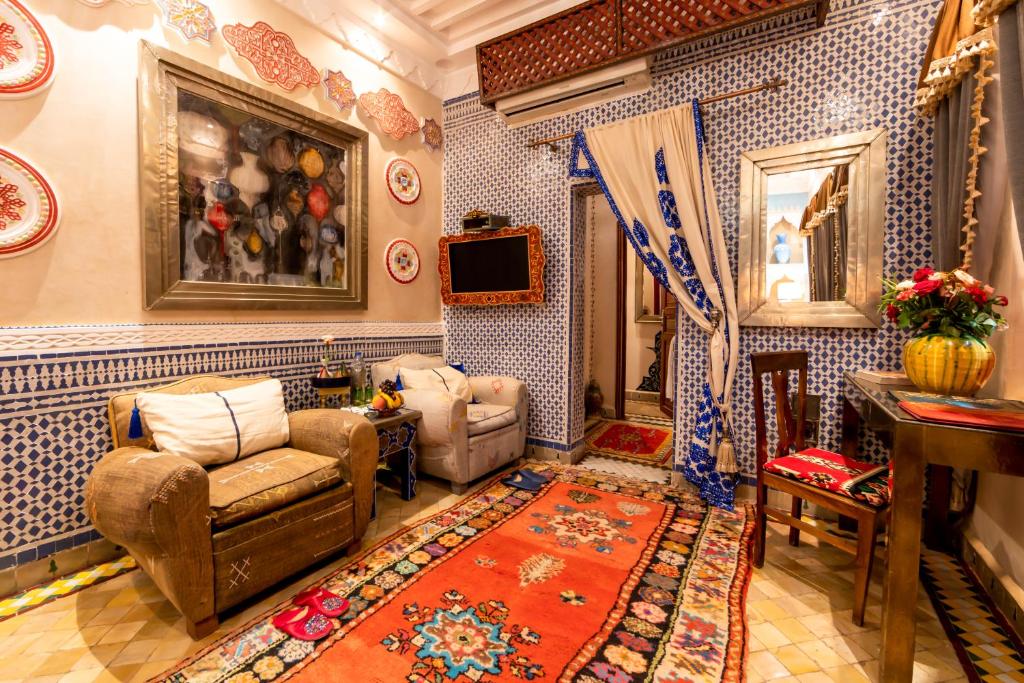 Una sala de estar con paredes de azulejos azules y blancos. en Riad Hikaya, en Marrakech