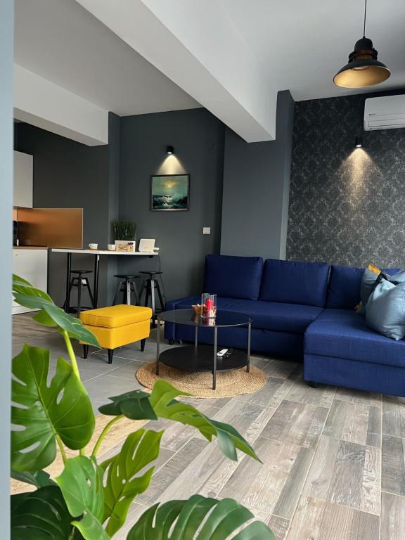 a living room with a blue couch and a table at Villa INTERMEZZO 11 sea view in Neoi Epivates