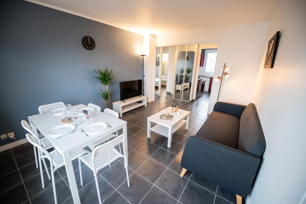 ein Wohnzimmer mit einem weißen Tisch und einem Sofa in der Unterkunft ROBESPIERRE - Tout équipé & Calme - TV et WIFI in Saint-Étienne