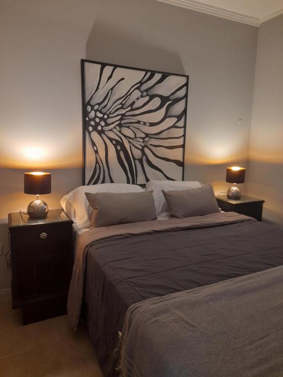 a bedroom with a large bed with two lamps on tables at Malala departamento en Santa Fe - ALOJAMIENTO DE CALIDAD in Santa Fe