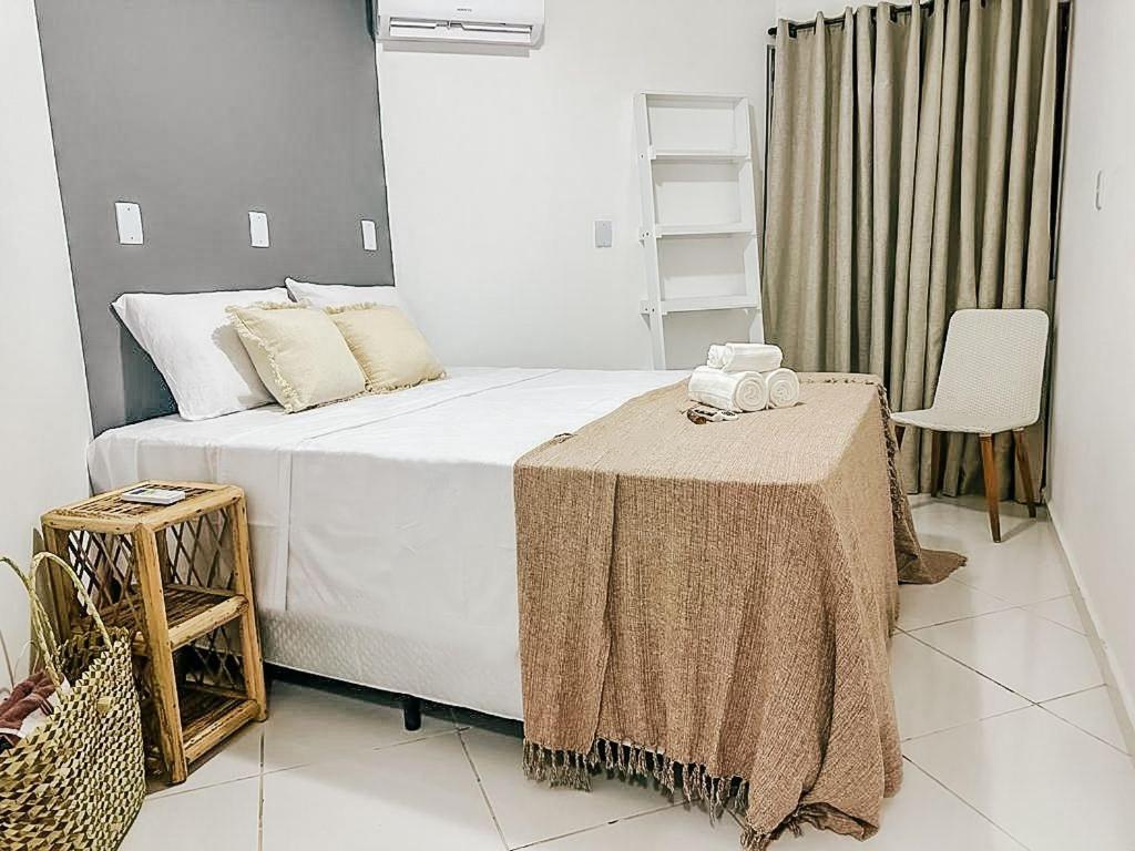 sypialnia z dużym łóżkiem ze stołem w obiekcie POUSADA MAR BELLO w mieście Paripueira