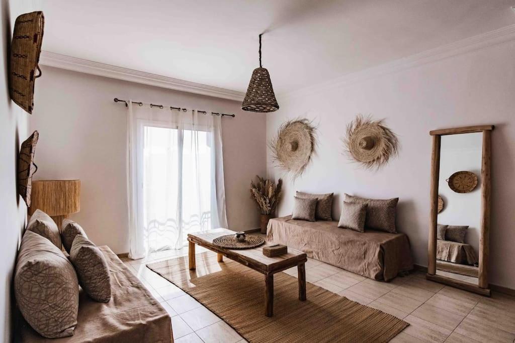 ein Wohnzimmer mit einem Sofa, einem Tisch und einem Spiegel in der Unterkunft Gueliz New Stylish Apartment Marrakech Sleeps 4 in Marrakesch