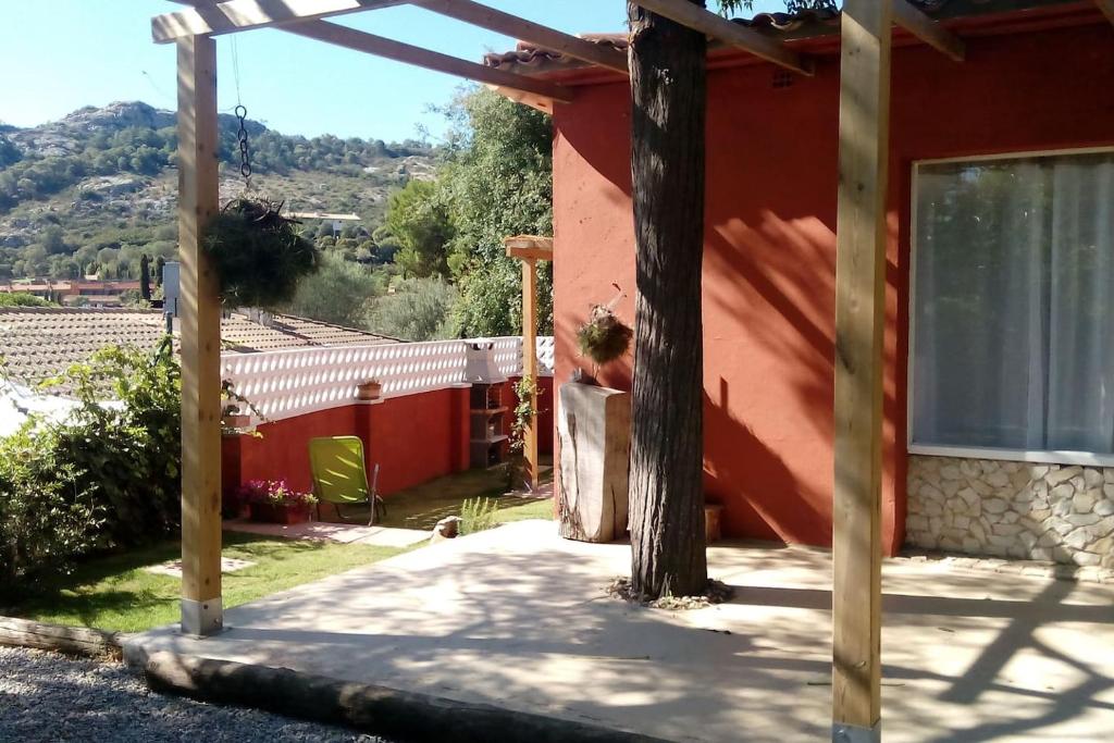 een patio van een rood huis met een boom bij Calma i descans a Begur in Begur