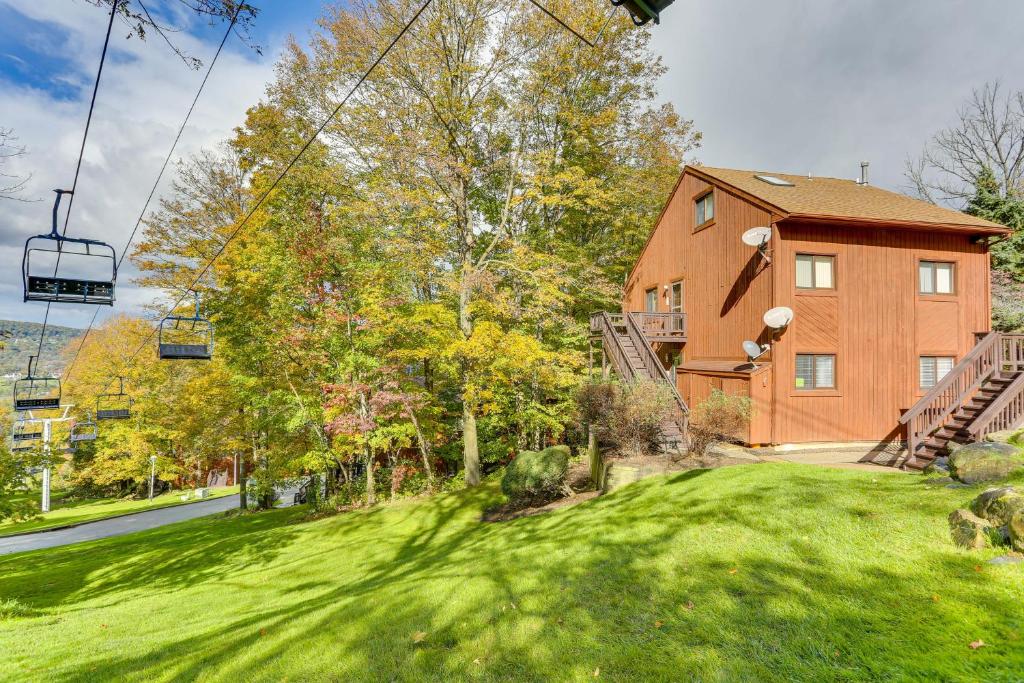 a house with a green yard with a ski lift at Modern Vernon Township Condo Near Ski and Water Park in Vernon Township