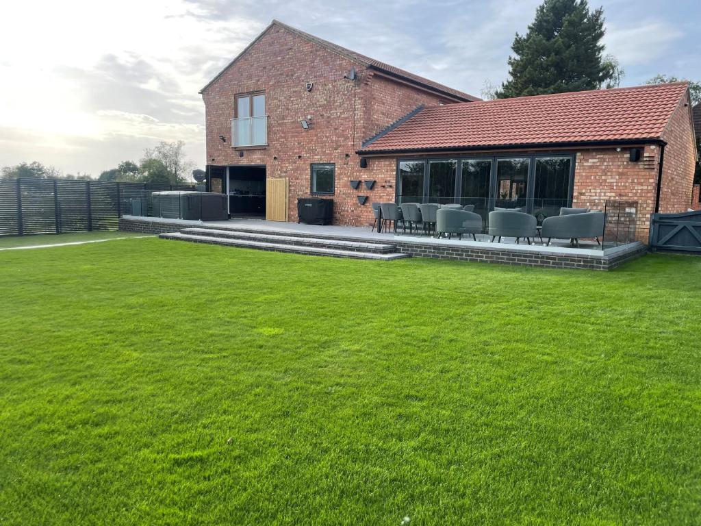 a lawn in front of a house with chairs at 85A Braybrooke Road in Kettering