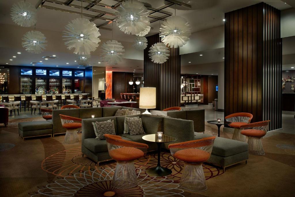 a hotel lobby with chairs and tables and chandeliers at Marriott St. Louis Airport in Edmundson