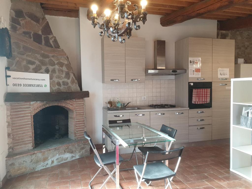 ヴェッキアーノにあるVacation Home Tuscany Filettole 3のガラステーブルと暖炉付きのキッチン