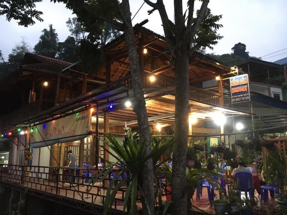 a building with people sitting outside of it at night at Hồng Gấm Homestay in Bak Kan