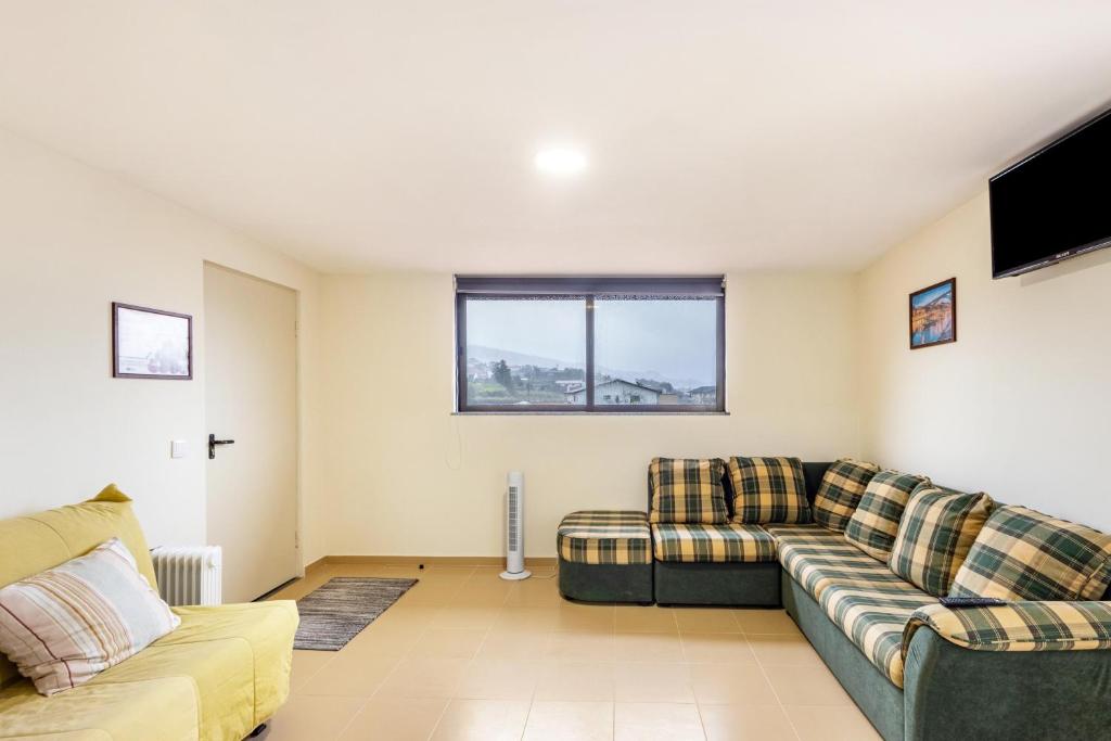 a living room with two couches and a tv at Casa T1 Área Metropolitana do Porto in Carregosa