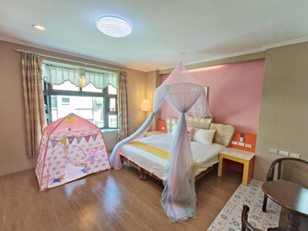 a bedroom with a bed with a canopy at 恆春古城親子民宿 in Hengchun South Gate