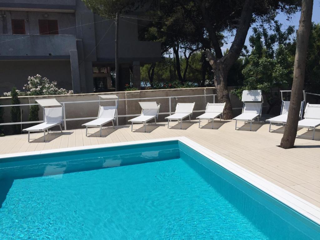 een groep stoelen en een zwembad bij La Villa Della Meda in Taranto