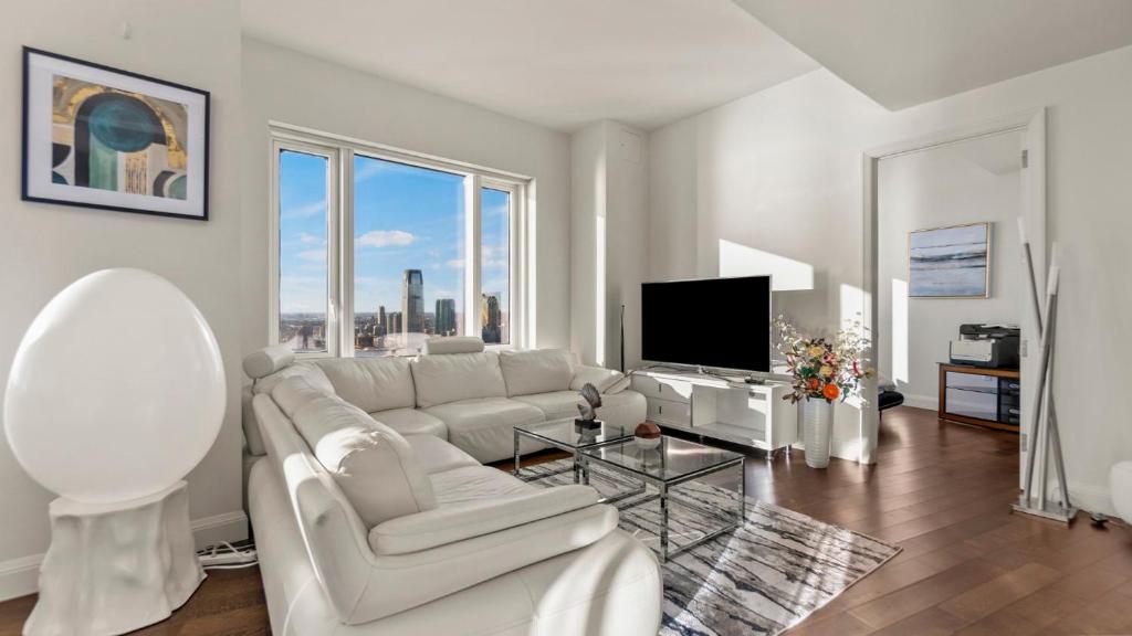 a living room with a white couch and a tv at Luxurious 4 BR Penthouse in NYC in New York