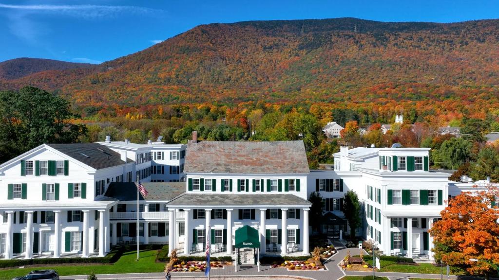 an aerial view of a white house with fall foliage at Equinox Resort Residences in Manchester