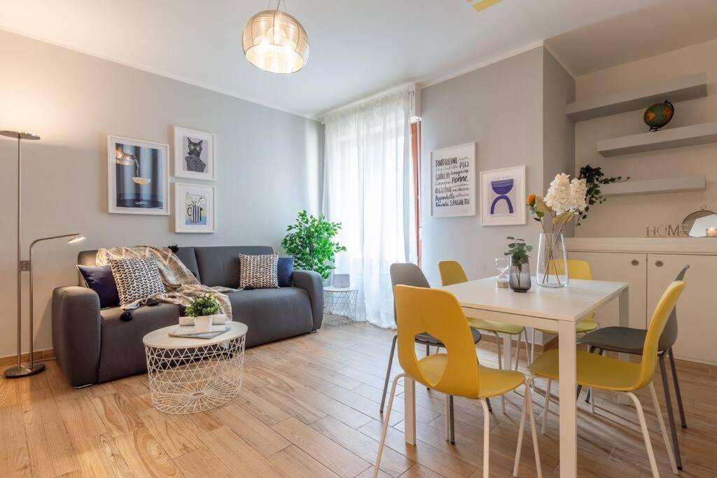 sala de estar con sofá, mesa y sillas en Ginger-Appartamento a due passi dal centro con posto auto - Porta Romana en Siena