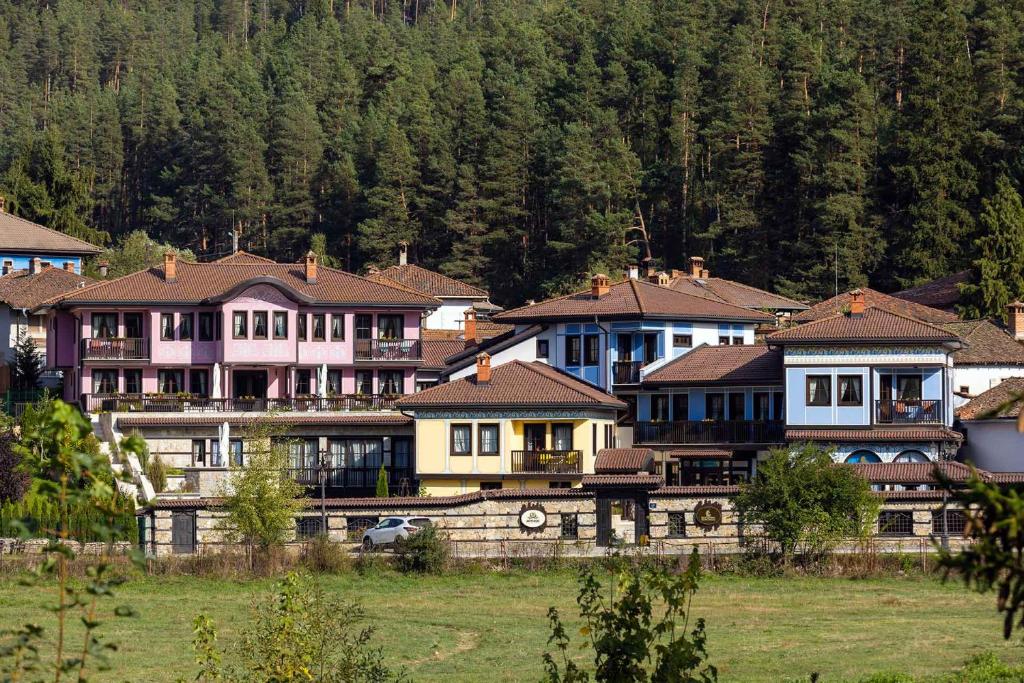 a group of houses in a village with trees at Armaco Residence in Koprivshtitsa