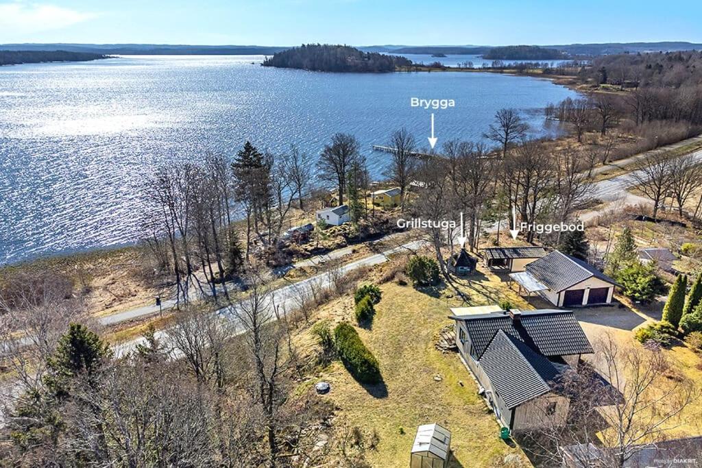 an aerial view of a house next to a lake at Sjönära hus med grillstuga & vacker omgivning in Gråbo