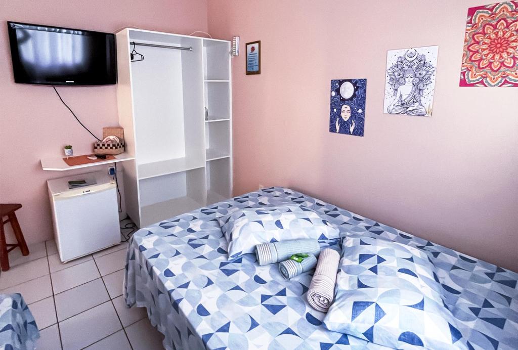 a bedroom with a bed with blue and white pillows at Pousada Águas do Embaú in Guarda do Embaú