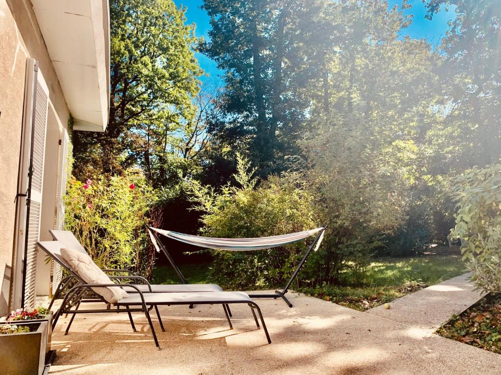 - un hamac et deux chaises sur la terrasse dans l'établissement Parc de BUC, à Buc