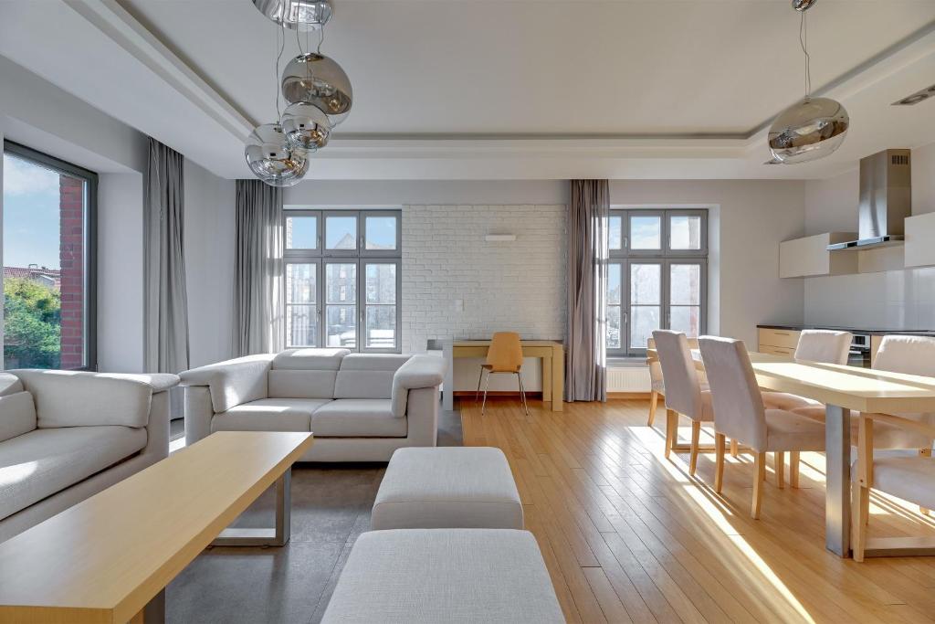 a living room with white furniture and a table at Dom & House Apartments - Old Town Tobiasz Residence - Fitness & Parking in Gdańsk