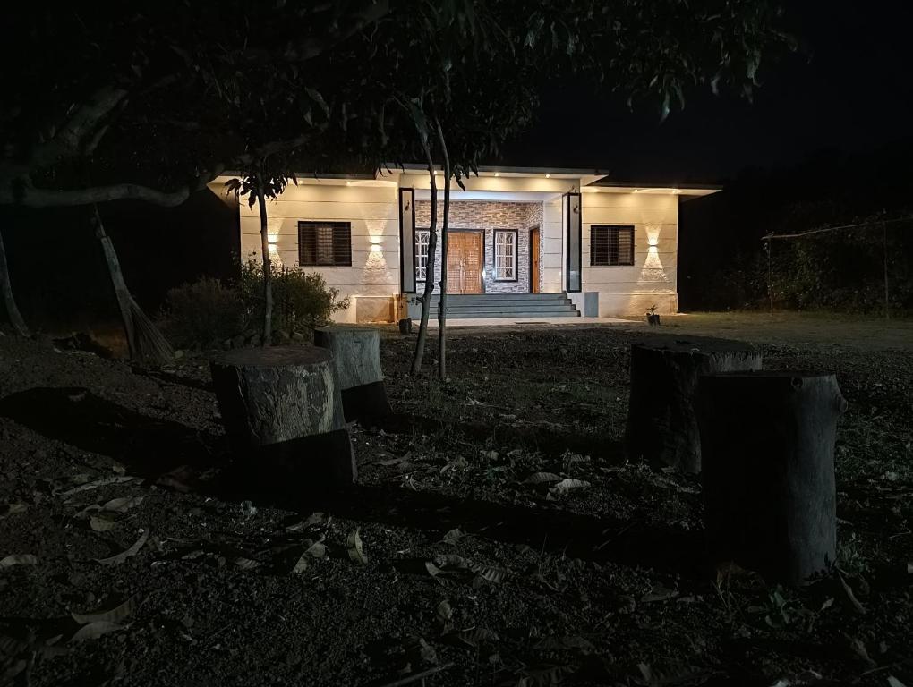 une maison la nuit avec les lumières allumées dans l'établissement Green Valley Resort, à Thāl