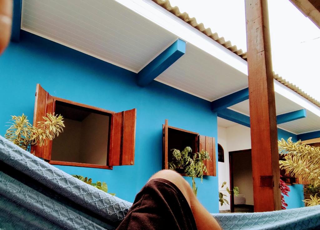 een persoon die op de trap van een huis zit bij Villavera - Caragua Centro in Caraguatatuba