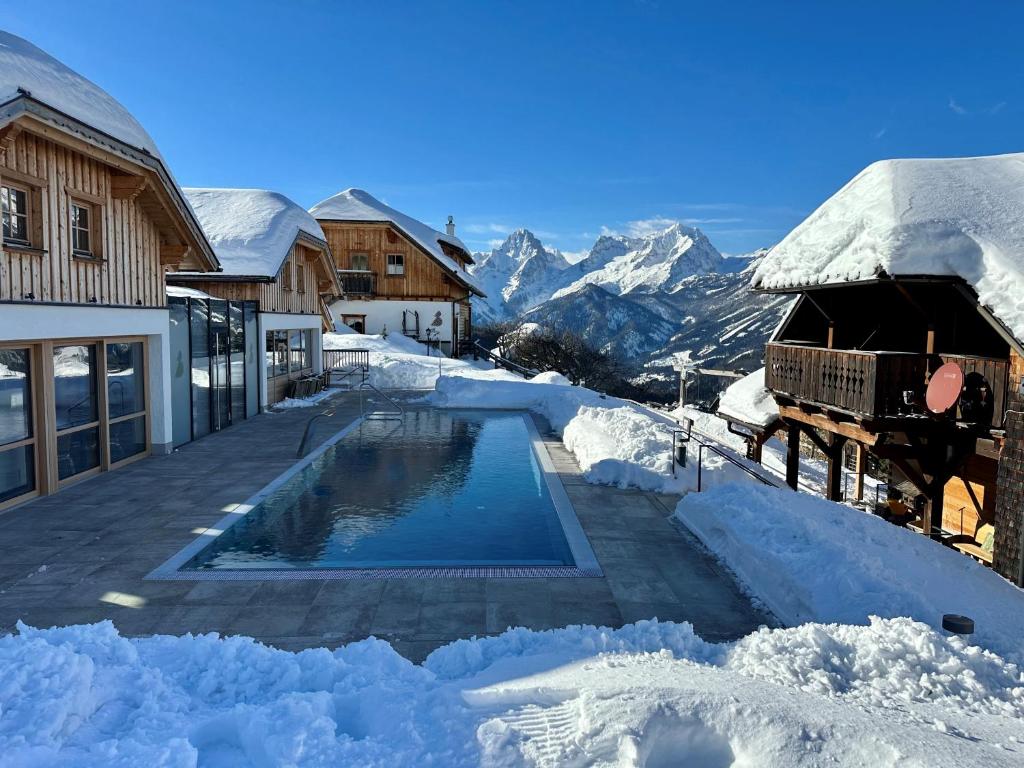 ein schneebedeckter Pool neben einem Haus in der Unterkunft Almresort Baumschlagerberg in Vorderstoder