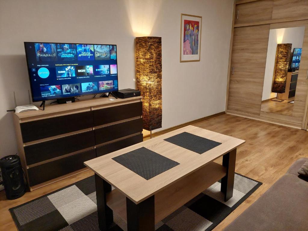 a living room with a tv and a coffee table at Apartament 59 , ranczoturystyka Bielawa Sudety in Bielawa
