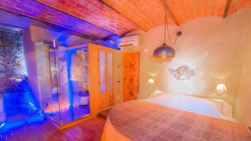 sypialnia z łóżkiem w pokoju z niebieskimi światłami w obiekcie Castello di Montalbano w mieście San Jacopo al Girone