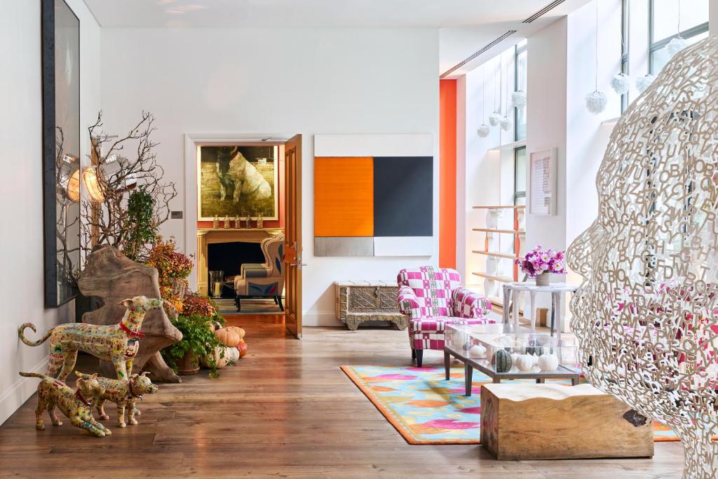 a living room filled with furniture and a fireplace at Crosby Street Hotel in New York