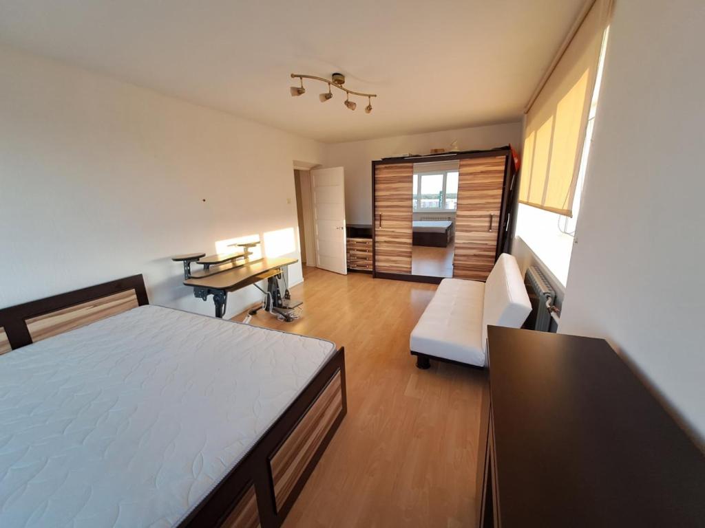 a bedroom with a bed and a desk and a couch at Hero Avenue Apartment in Narva