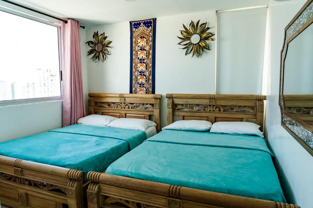 two beds in a room with blue sheets at Ocean View Apartments IH RENTALS in Cartagena de Indias