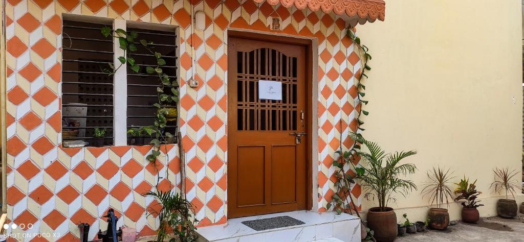 un edificio arancione e bianco con porta in legno di Satvik Stays a Puri