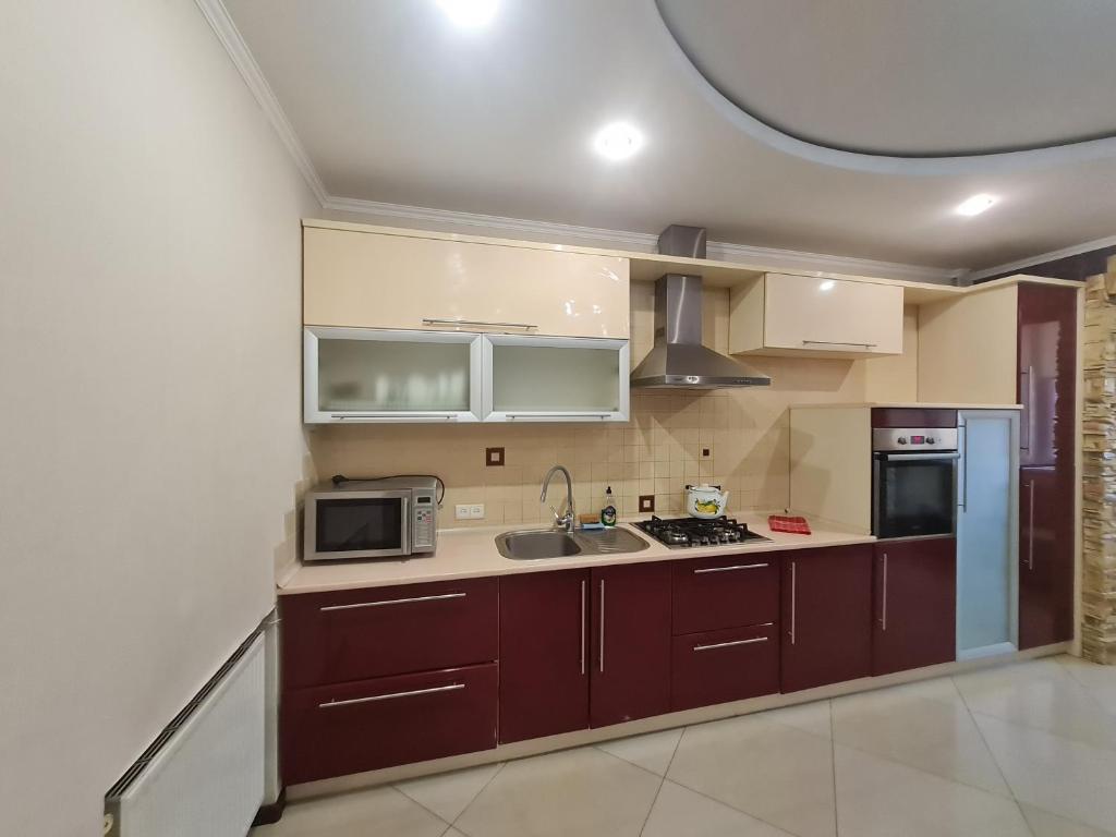 a kitchen with a sink and a microwave at Apartment on Kravchuka 11b in Lutsk