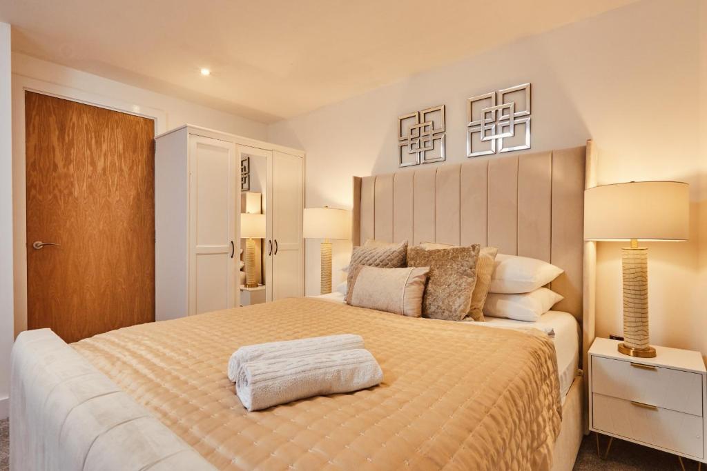 a bedroom with a large bed and two lamps at Modern Leeds Dock Apt &Free Secure Parking! in Leeds