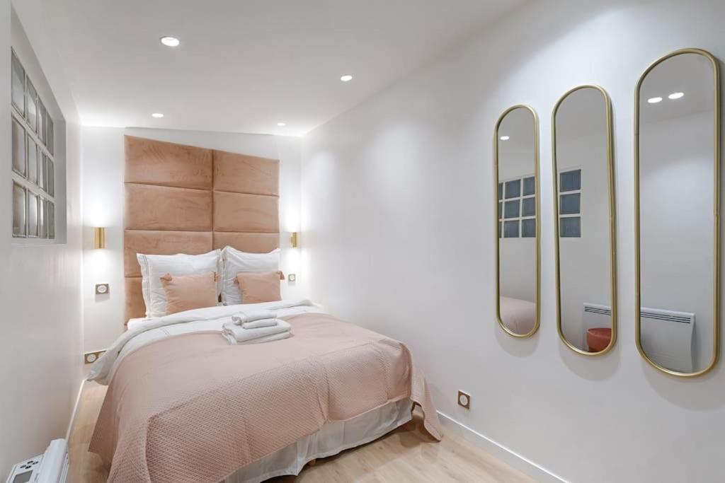 - une chambre avec un grand lit et trois miroirs dans l'établissement Coeur du Marais Arts&Metiers Magnifique Appartement, à Paris
