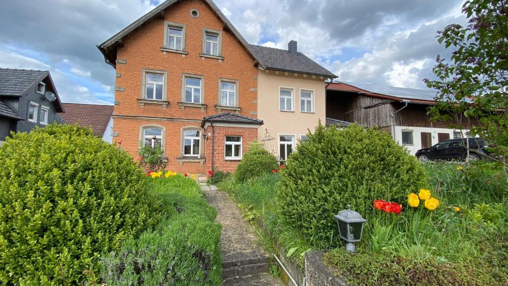 a house with a garden in front of it at Charmante Bauernhofwohnung in Lautertal in Lautertal