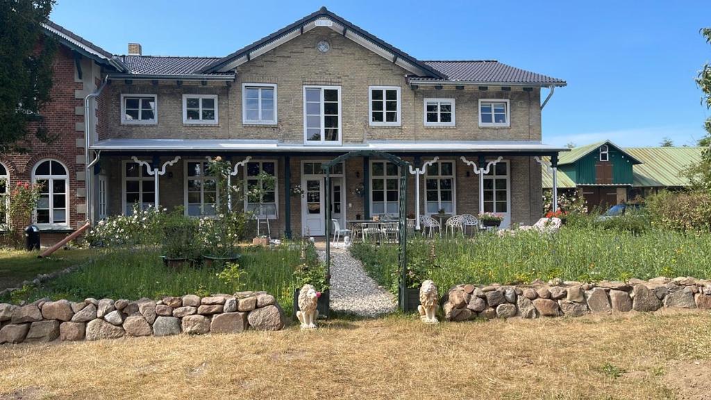 dos perros parados frente a una casa en Hof Sonnenmeer - Ostsee - nachhaltig - ökologisch & wunderschön, en Prasdorf