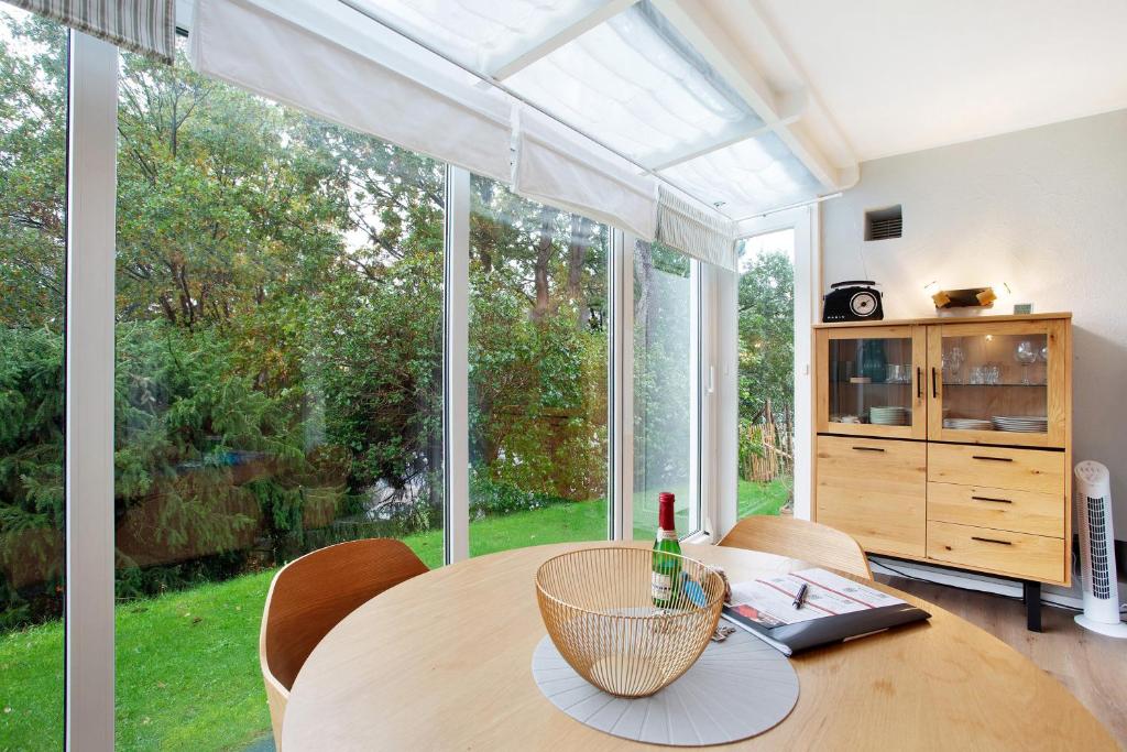 Un comedor con una mesa y un gran ventanal. en Ferienwohnung Bergwiese, en Schmallenberg