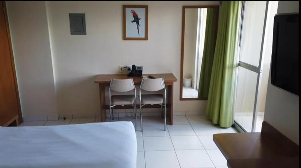 ein Schlafzimmer mit Tisch und Stühlen und einem Bett in der Unterkunft Golden Dolphin Grand Hotel - Caldas Novas in Caldas Novas