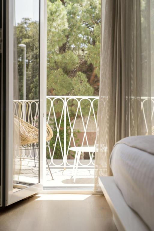 a bedroom with a door open to a balcony at Le Palmette Suites in Cagliari