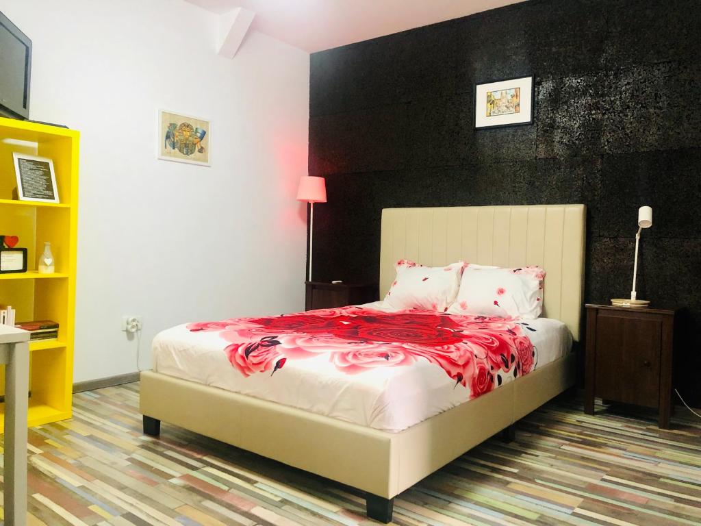 Un dormitorio con una cama con una manta roja. en Cazare urbana, en Brasov