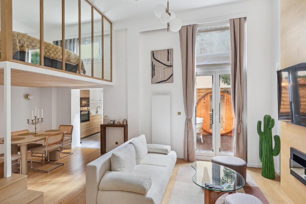 een woonkamer met een bank en een eetkamer bij Suite luxueuse avec jardin privé Sauna et Jacuzzi in Parijs