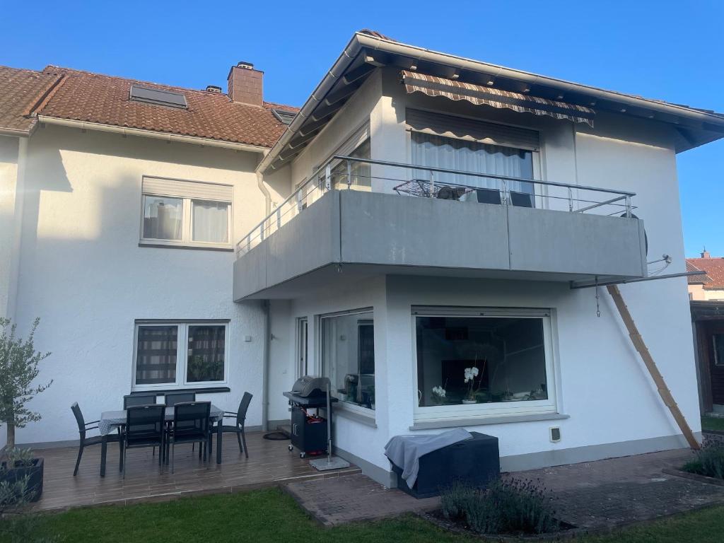 Casa con balcón, mesa y sillas en Ferienwohnung en Donaueschingen