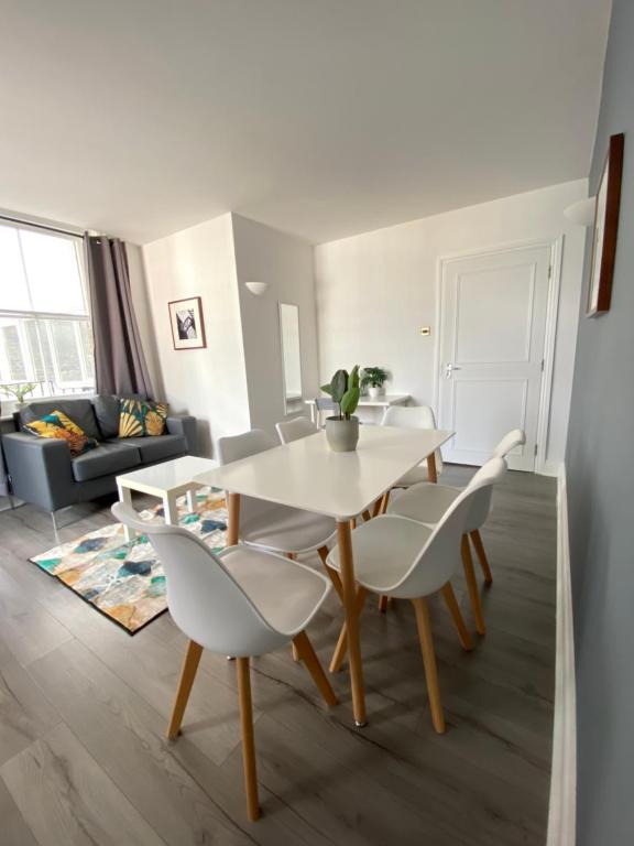 uma sala de estar com uma mesa branca e cadeiras em Stylish Central Escape em Londres