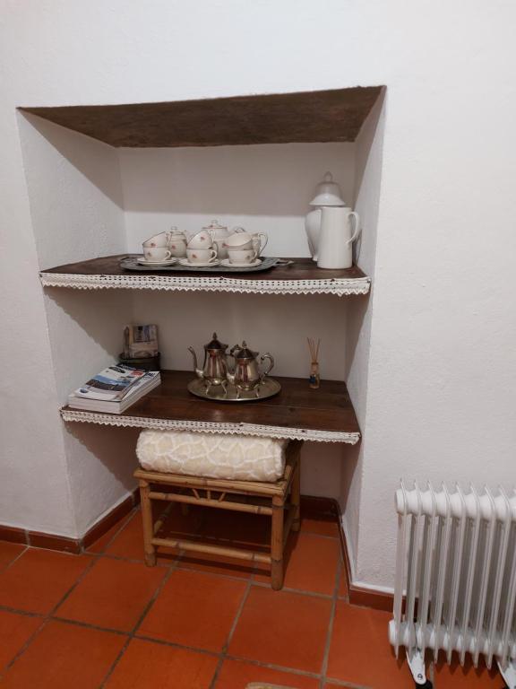 Habitación pequeña con estantería con set de té. en A Casinha da Vila en Vila Viçosa