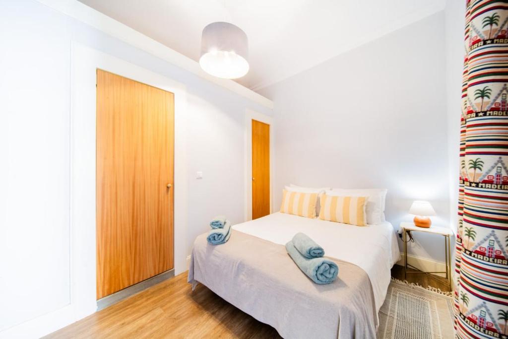 - une chambre avec un lit et des serviettes bleues dans l'établissement Casa na Ilha III, à Funchal