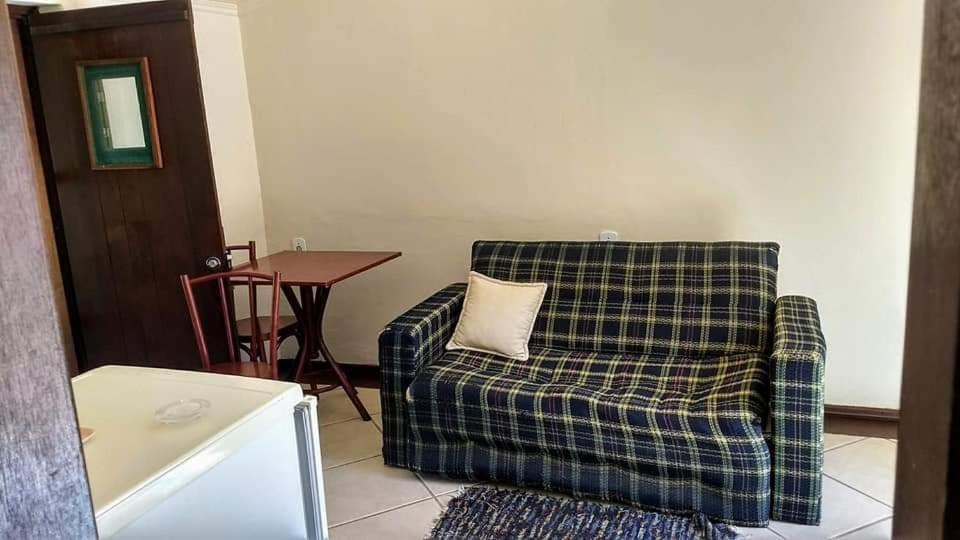 ein Wohnzimmer mit einem karierten Stuhl und einem Tisch in der Unterkunft Pousada do sobrado in Bagé